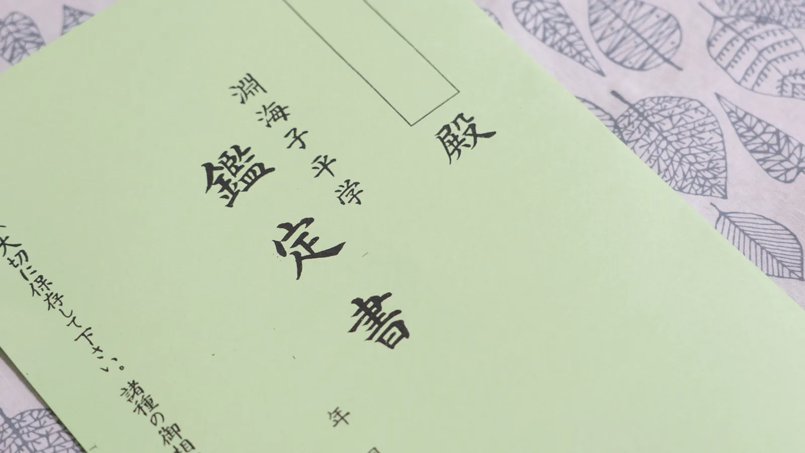 テーブルで鑑定書に目を通す女性